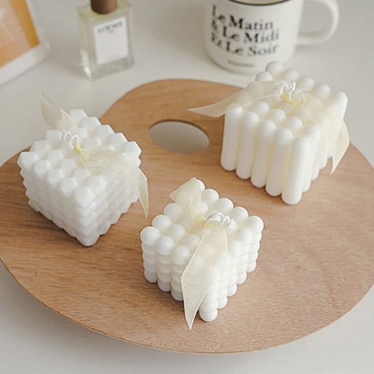 White bubble candles on wooden tray