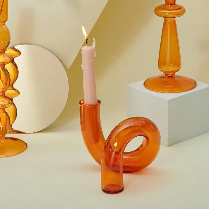 Orange glass candle holder with lit candle