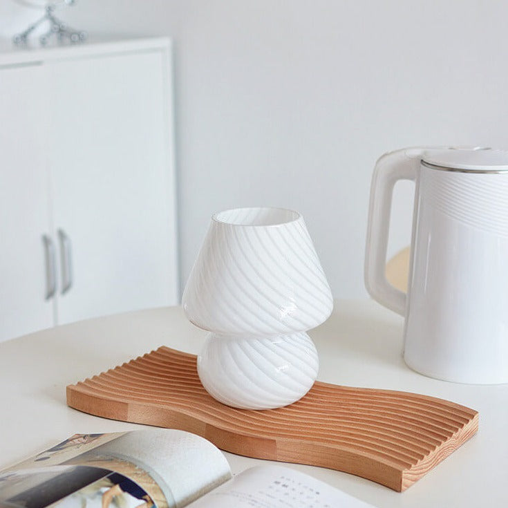 White mushroom lamp on wooden tray.
