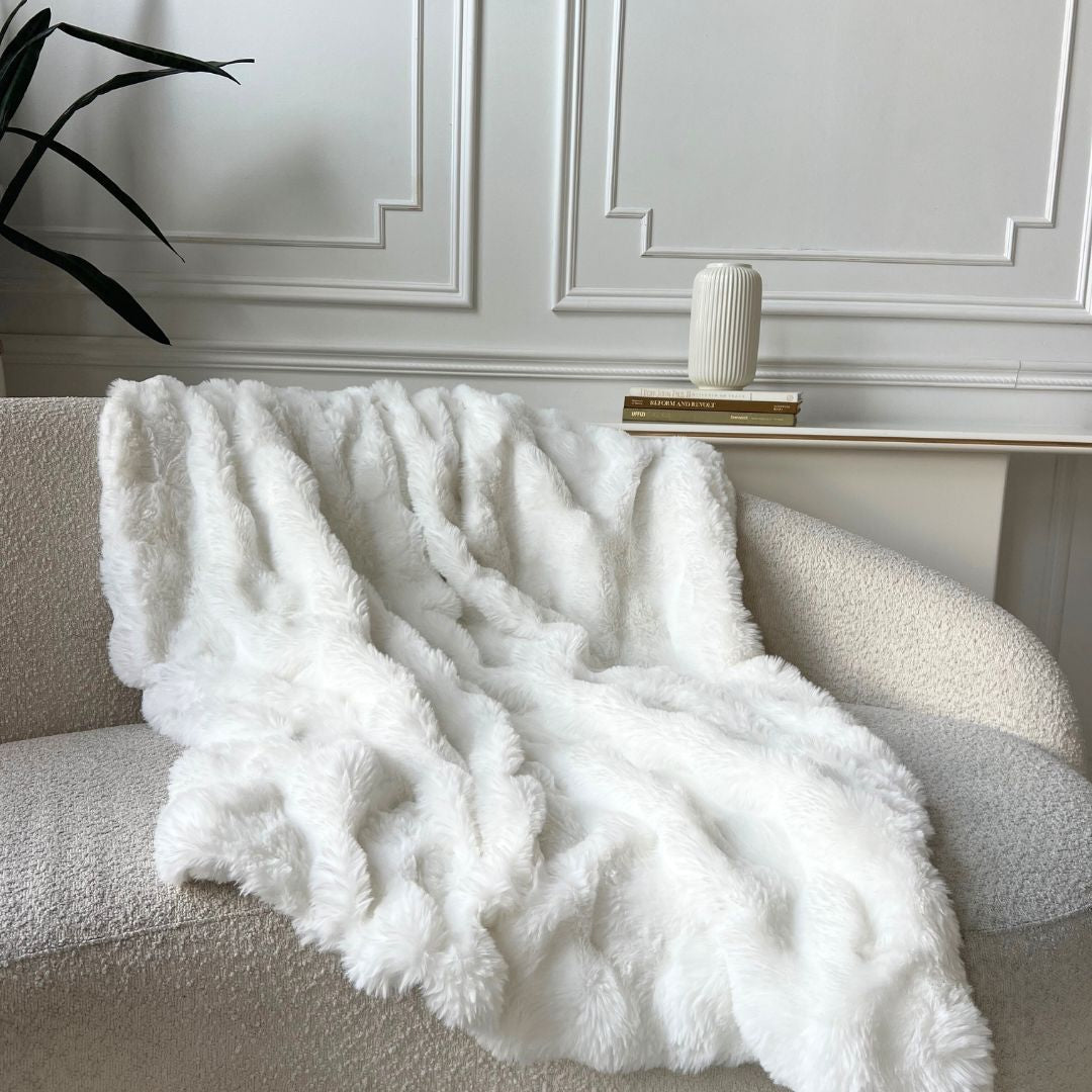 White fluffy blanket draped over a sofa.