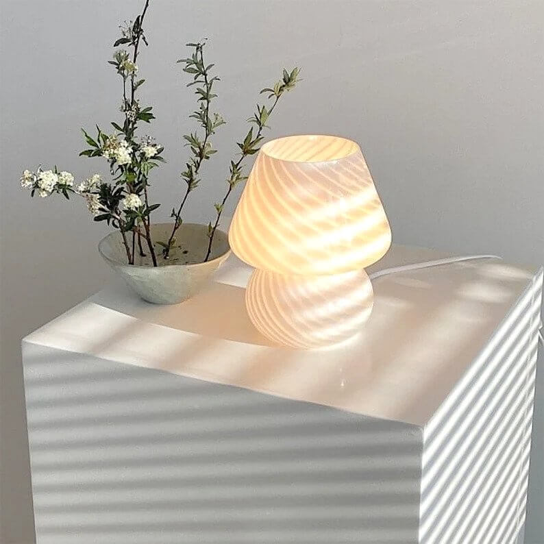 Mushroom lamp and flowers on a white surface
