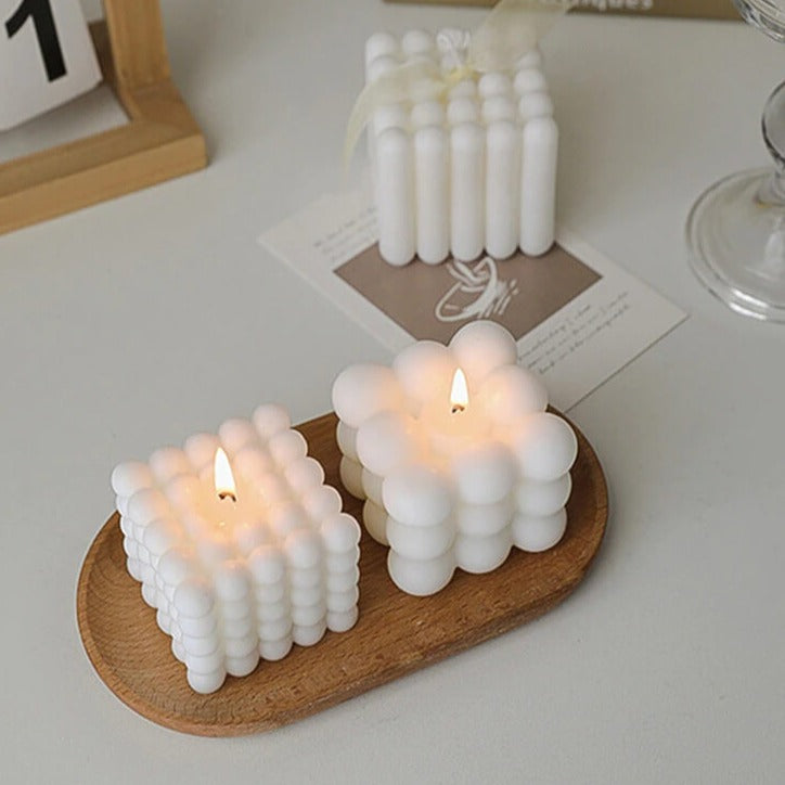 White bubble candles on wooden tray