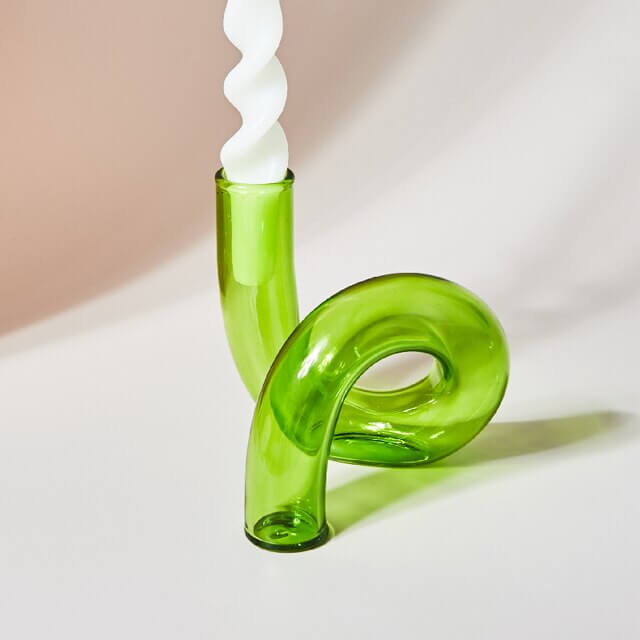 Green glass candle holder with white spiral candle