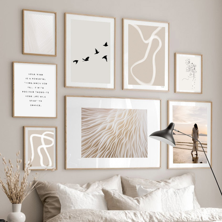 Gallery wall with abstract art and woman on beach.