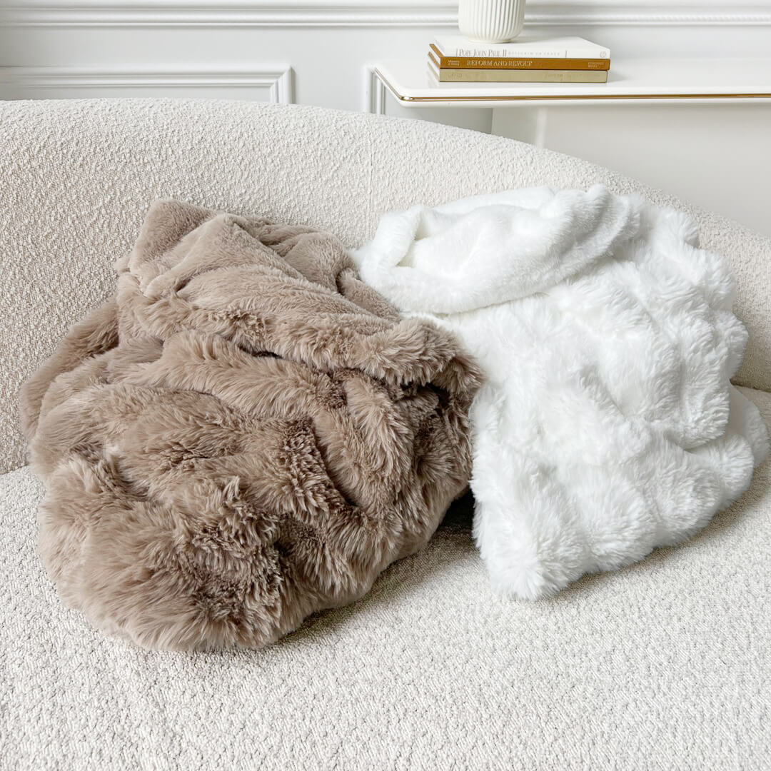 Coffee and white faux fur throw blanket draped over a couch
