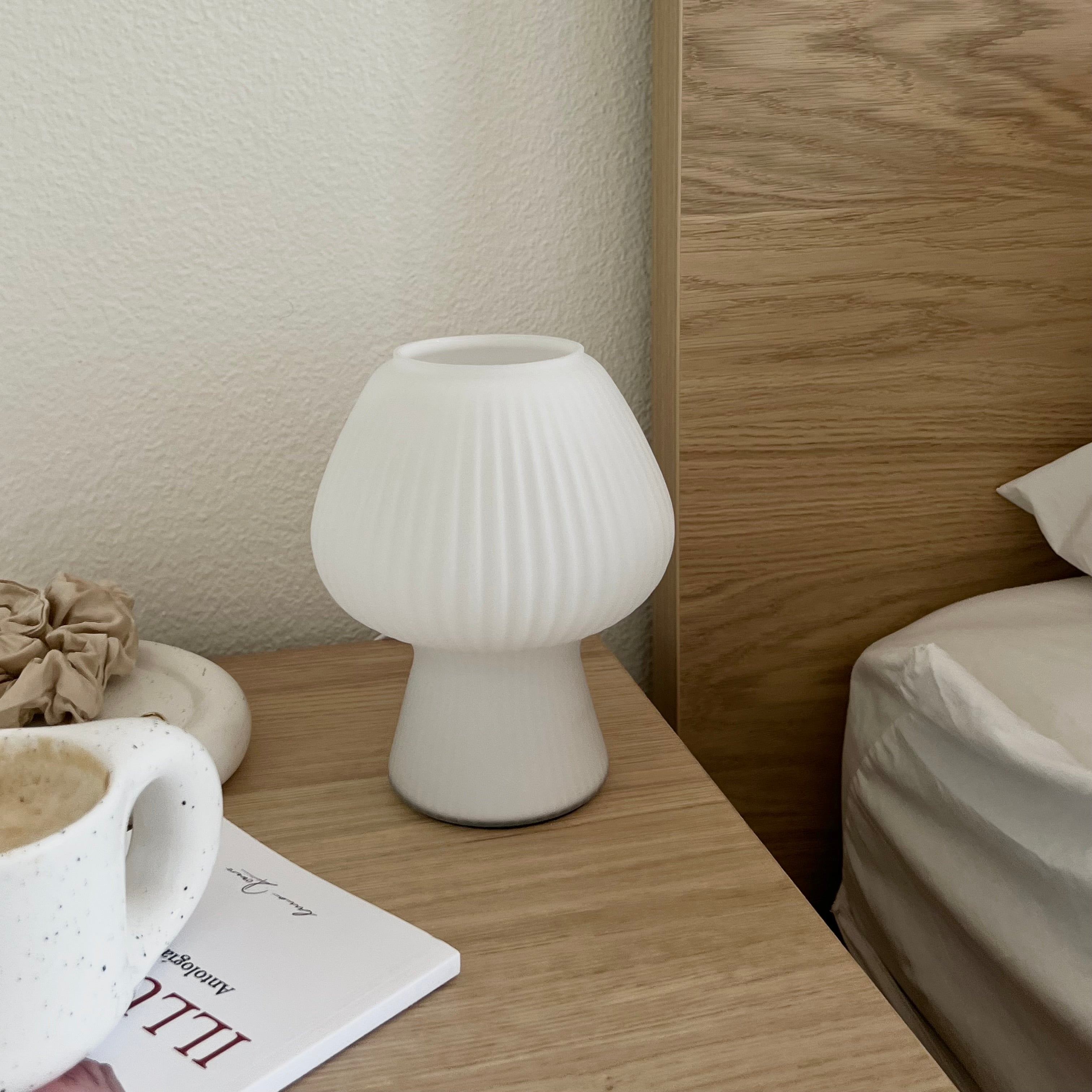 White mushroom-shaped lamp on a nightstand.